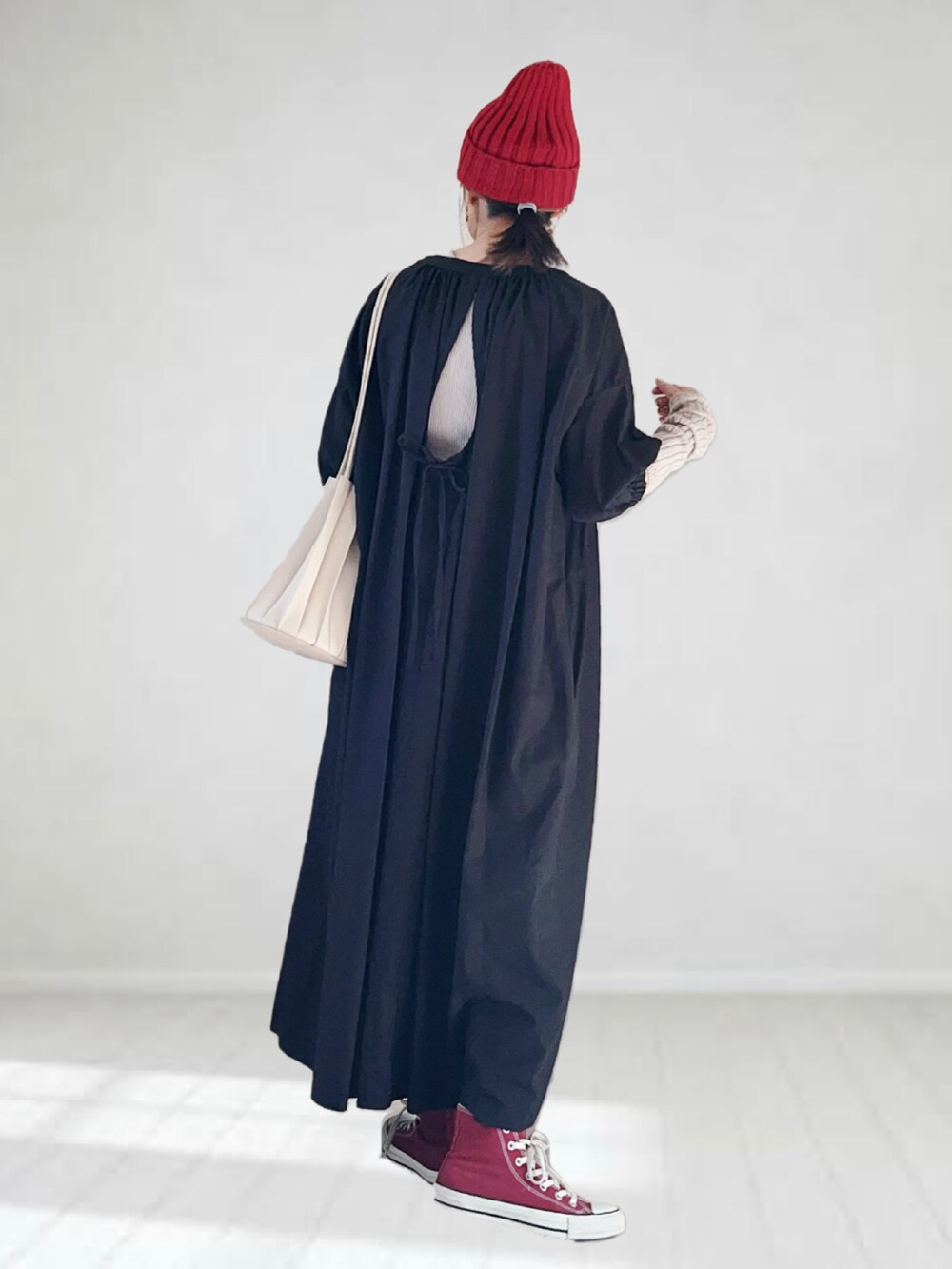 ブラック系のワンピース、ベージュ系のタンクトップ、ベージュ系のショルダーバッグを着用したレディースの秋コーディネートの2枚目の写真