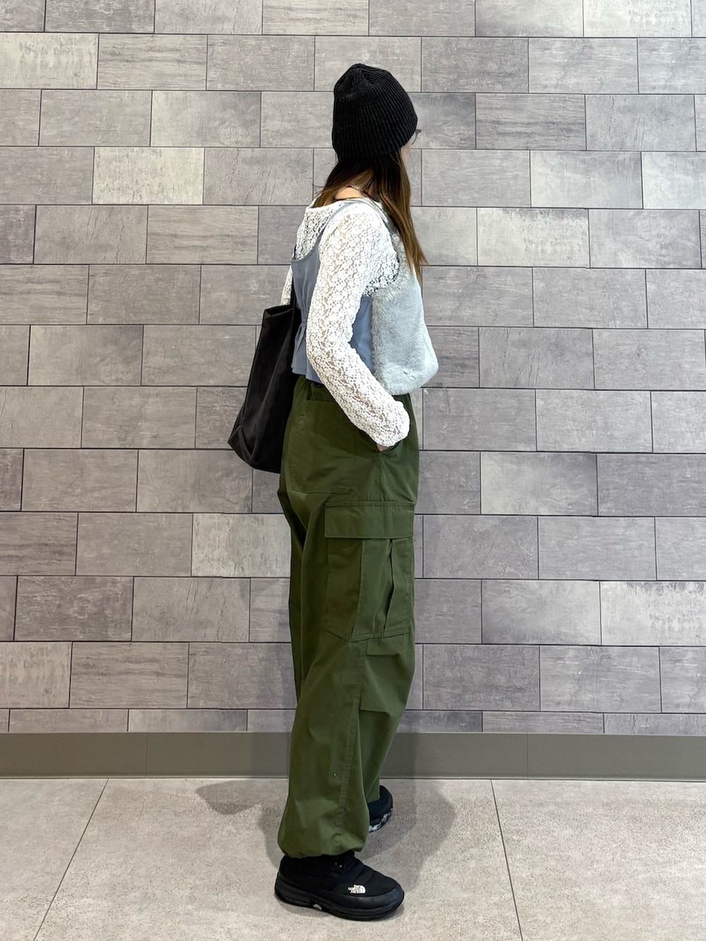 グレー系のトートバッグ、ホワイト系のTシャツ/カットソー、グリーン系のカーゴパンツを着用したレディースの冬コーディネートの5枚目の写真