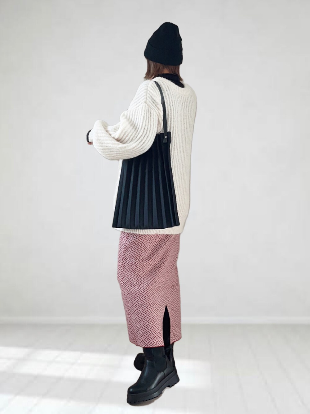 ホワイト系のカーディガン/ボレロ、ブラック系のTシャツ/カットソー、レッド系のスカートを着用したレディースの冬コーディネートの4枚目の写真