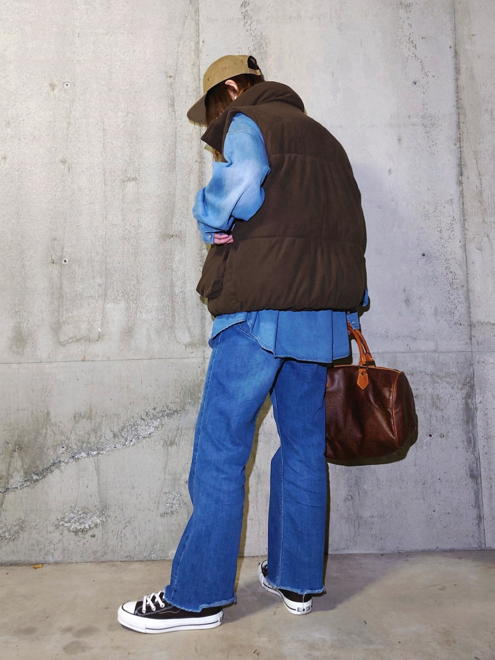 ブラウン系のダウンベスト、ブルー系のシャツ/ブラウス、ブラウン系のスニーカーを着用したレディースの秋コーディネートの3枚目の写真