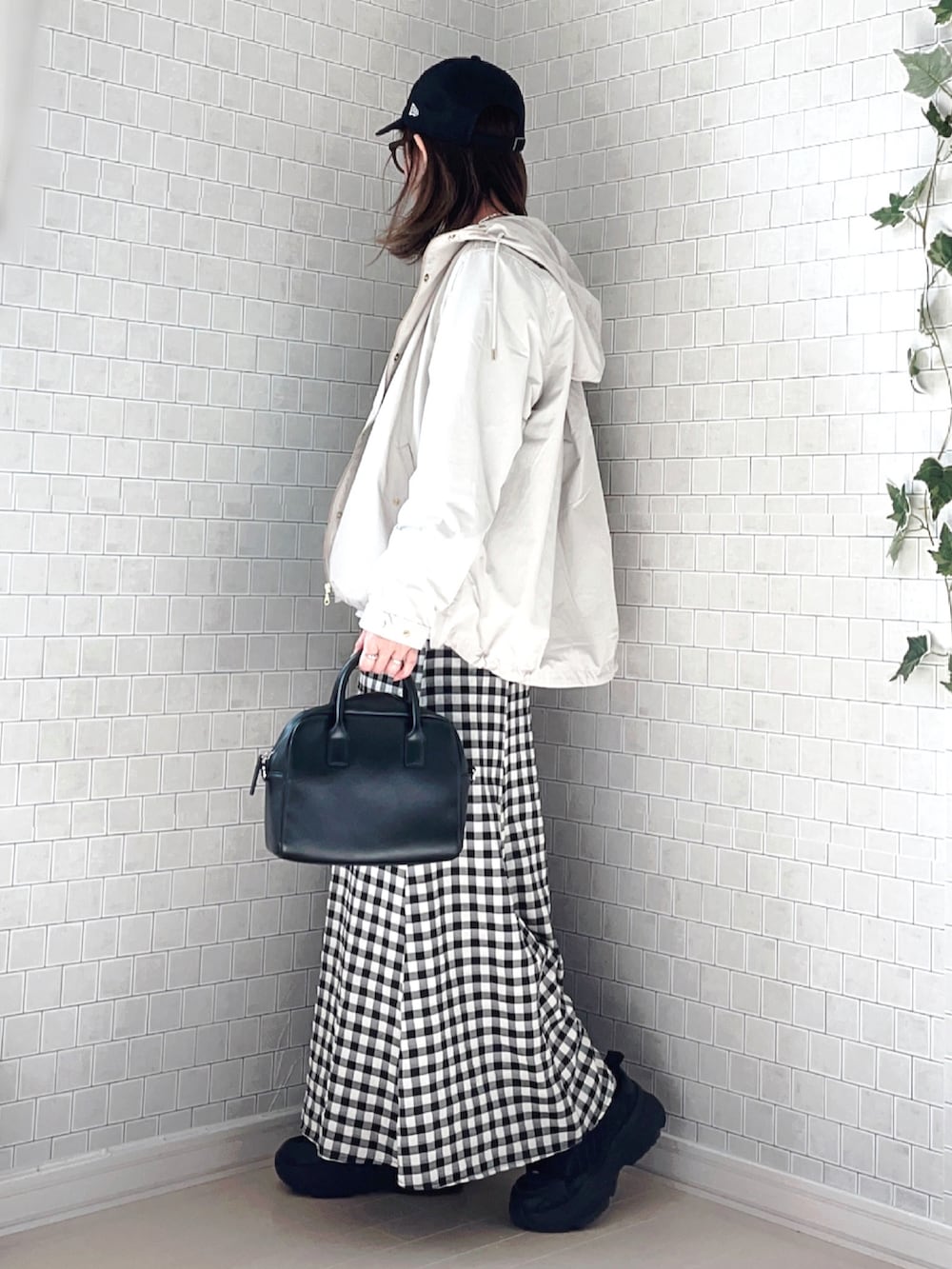 ホワイト系のマウンテンパーカー、ブルー系のTシャツ/カットソー、ブラック系のスカートを着用したレディースの春コーディネートの2枚目の写真