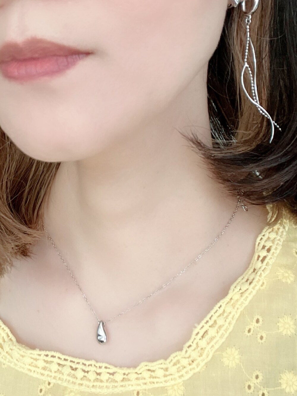 ブルー系のデニムパンツ、ホワイト系のトートバッグ、ブラウン系のサンダルを着用したレディースの夏コーディネートの4枚目の写真