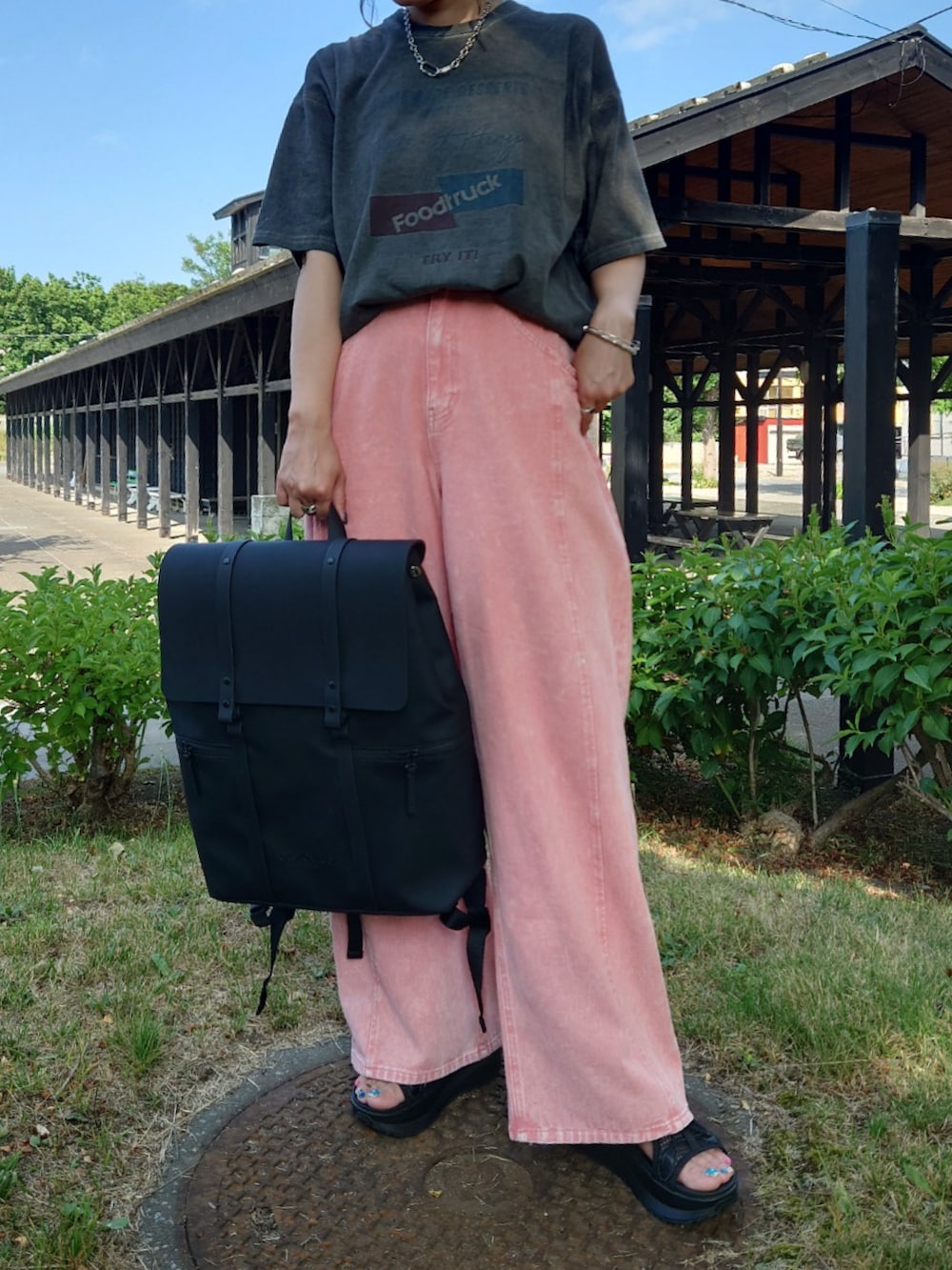 ブラック系のバックパック/リュック、グレー系のTシャツ/カットソー、ブラック系のサンダルを着用したレディースの夏コーディネートの2枚目の写真