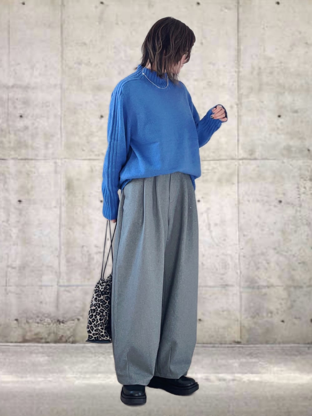 ブルー系のニット/セーター、グレー系のその他パンツ、ブラック系のブーツを着用したレディースの冬コーディネートの2枚目の写真