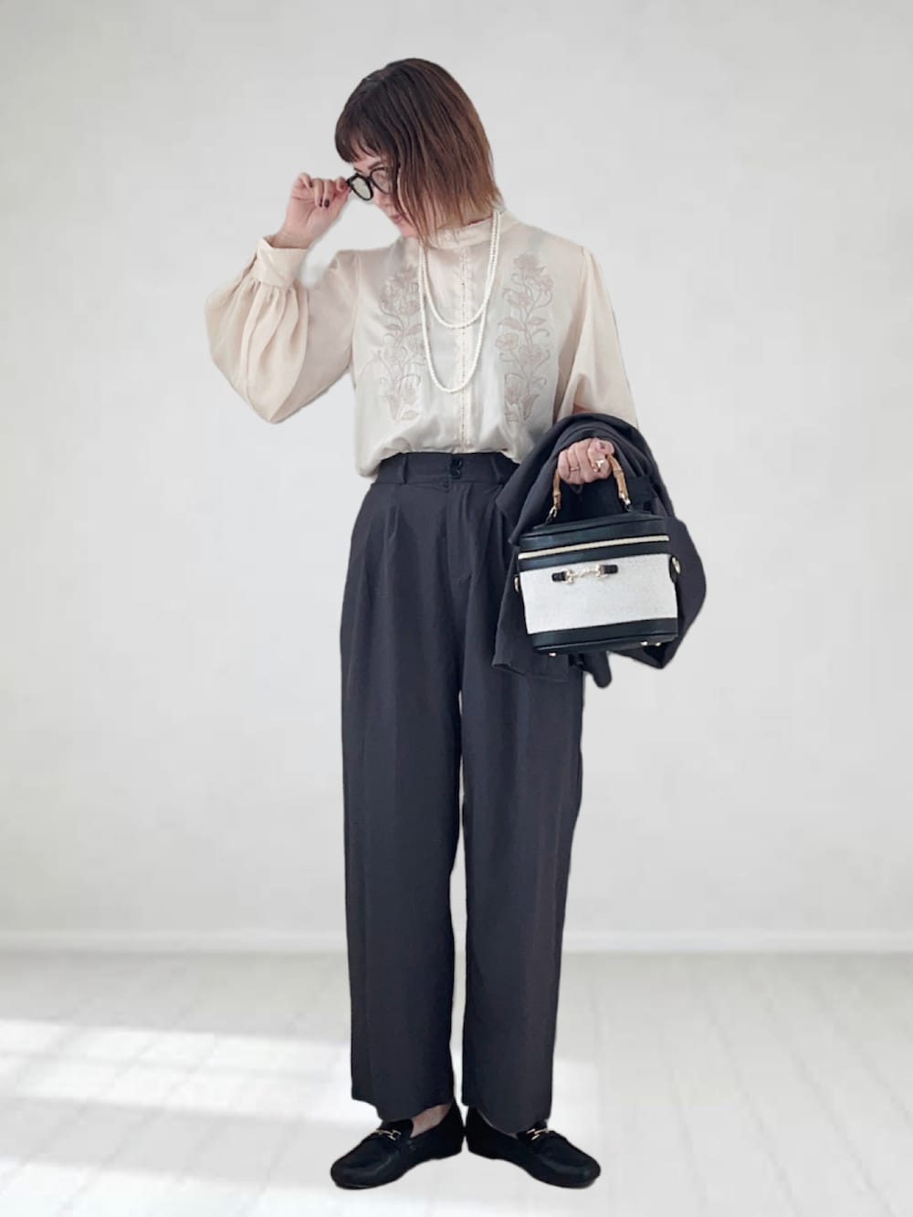 グレー系のテーラードジャケット、ホワイト系のシャツ/ブラウス、ホワイト系のハンドバッグを着用したレディースの冬コーディネートの3枚目の写真