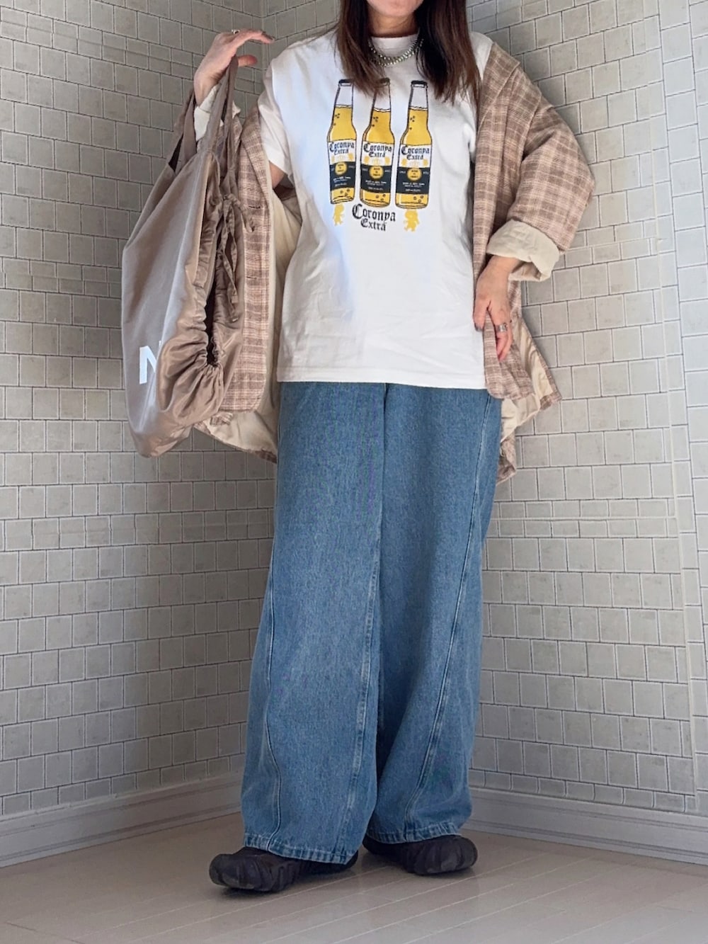 ホワイト系のTシャツ/カットソー、ベージュ系のテーラードジャケット、ブラウン系のスニーカーを着用したレディースの春コーディネートの4枚目の写真