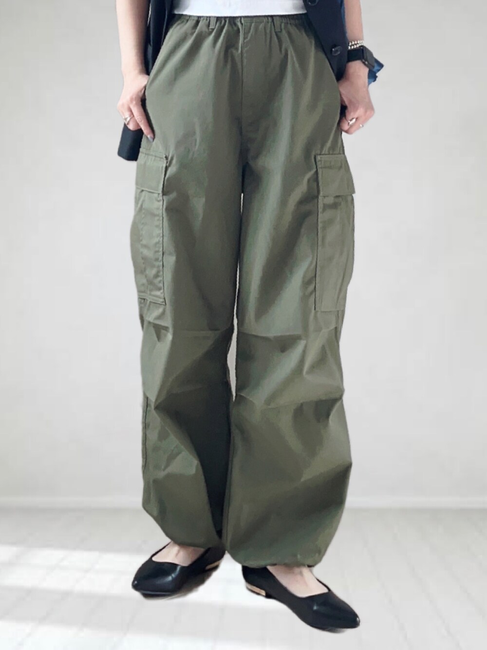 ホワイト系のTシャツ/カットソー、ブラック系のベスト、グリーン系のカーゴパンツを着用したレディースの春コーディネートの3枚目の写真