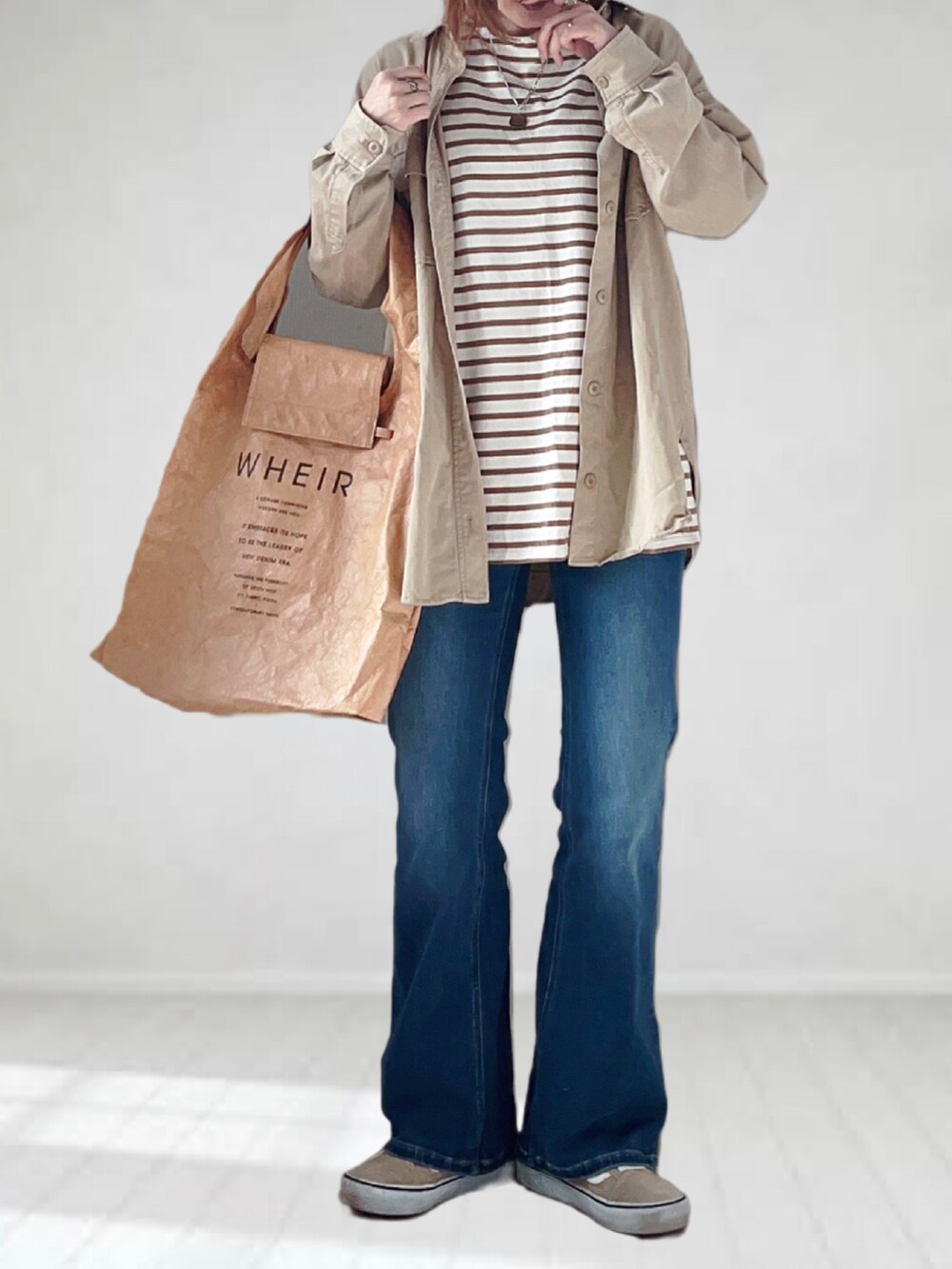 ブルー系のデニムパンツ、ブラウン系のTシャツ/カットソー、ベージュ系のシャツ/ブラウスを着用したレディースの春コーディネートの4枚目の写真