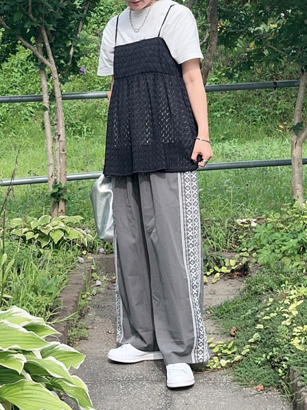 グレー系のその他パンツ、ブラック系のTシャツ/カットソー、ホワイト系のスニーカーを着用したレディースの夏コーディネートの2枚目の写真