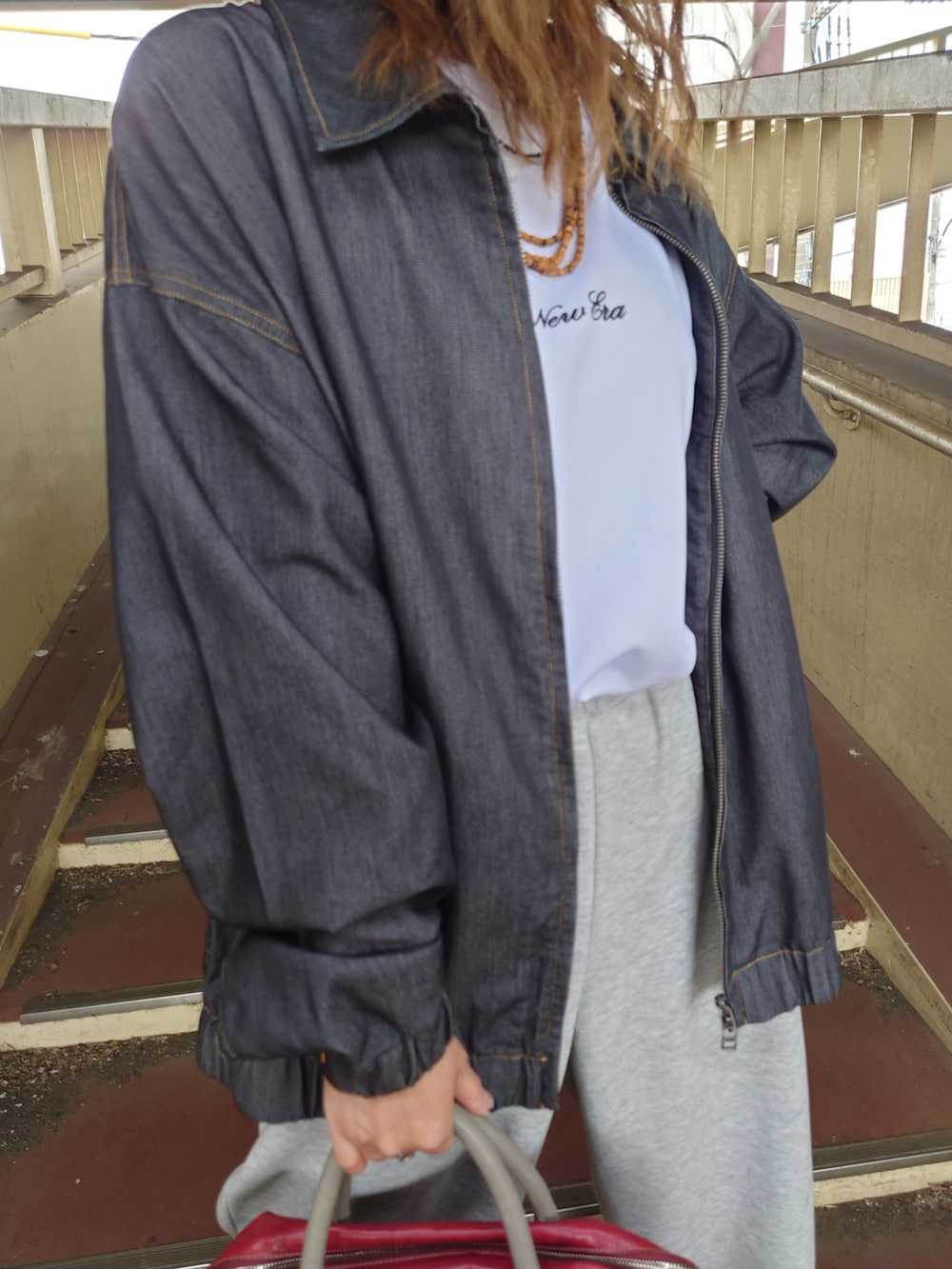 ブラック系のブルゾン、ホワイト系のTシャツ/カットソー、ホワイト系のスニーカーを着用したレディースの夏コーディネートの4枚目の写真