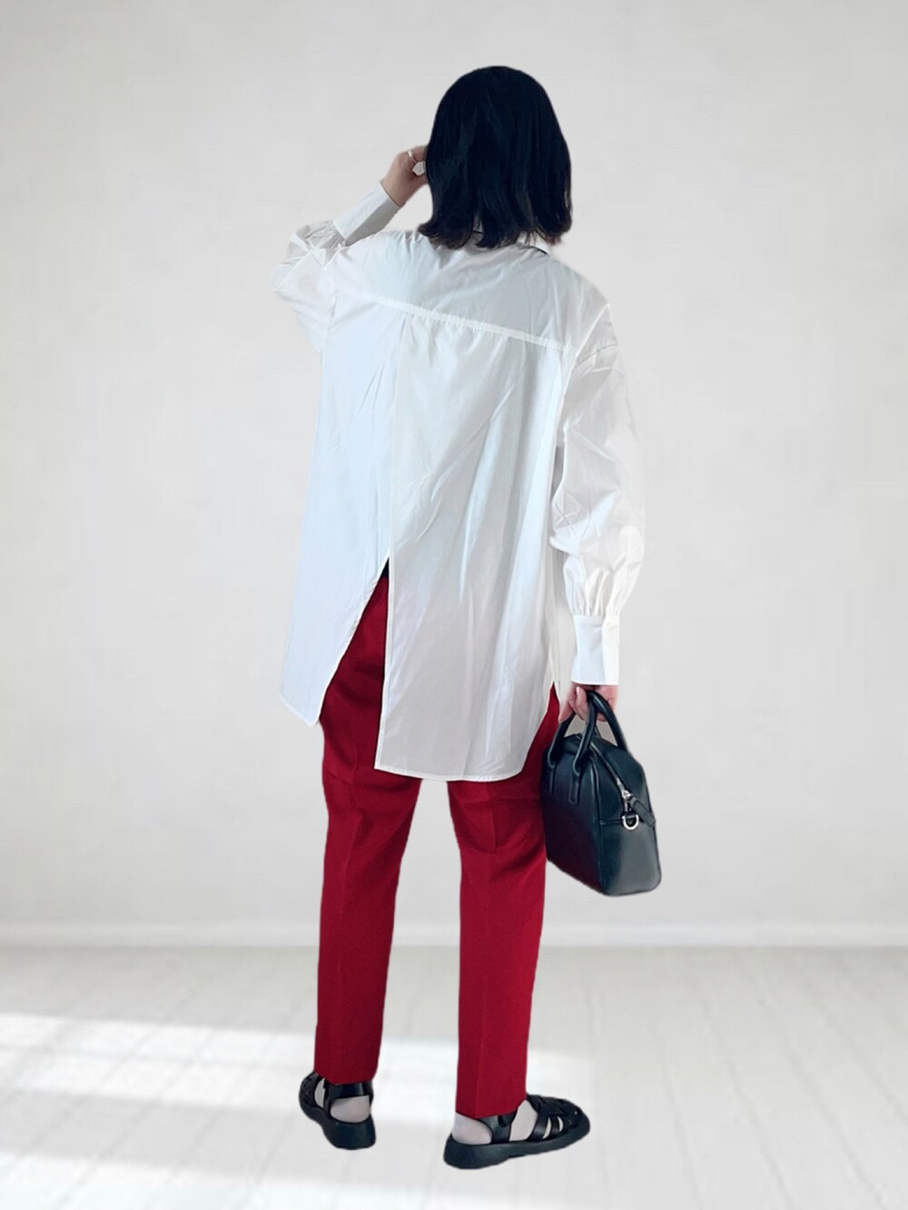 ホワイト系のシャツ/ブラウス、レッド系のスラックス、ブラック系のボストンバッグを着用したレディースの春コーディネートの3枚目の写真
