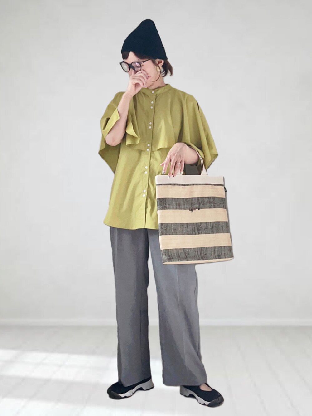 グリーン系のシャツ/ブラウス、グレー系のデニムパンツ、ブラック系のトートバッグを着用したレディースの夏コーディネートの2枚目の写真