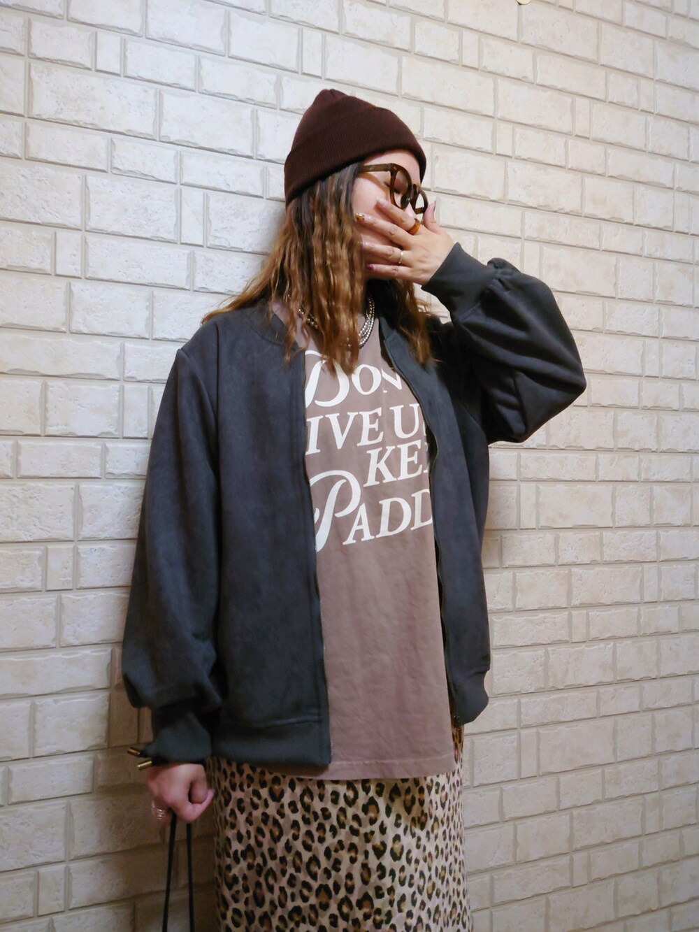 グレー系のブルゾン、ブラック系のショルダーバッグ、ブラウン系のTシャツ/カットソーを着用したレディースの秋コーディネートの3枚目の写真
