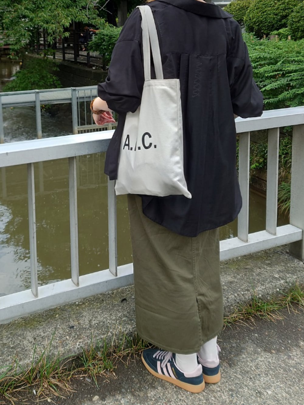 グリーン系のスカート、ブラック系のシャツ/ブラウス、ブラック系のTシャツ/カットソーを着用したレディースの秋コーディネートの4枚目の写真