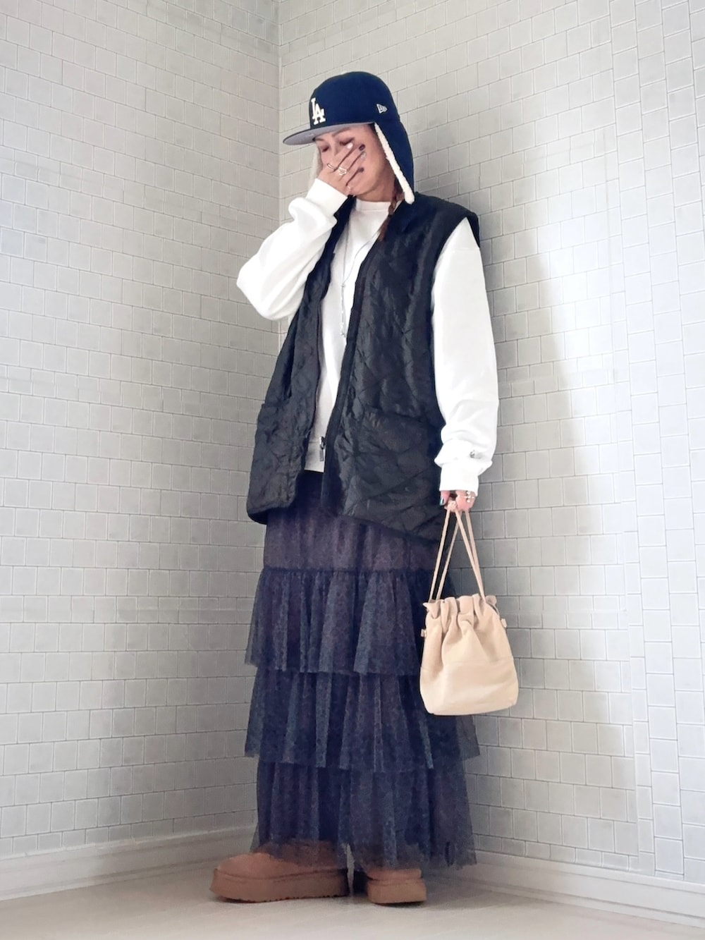 その他のスカート、ブラウン系のブーツ、グリーン系のベストを着用したレディースの冬コーディネートの4枚目の写真