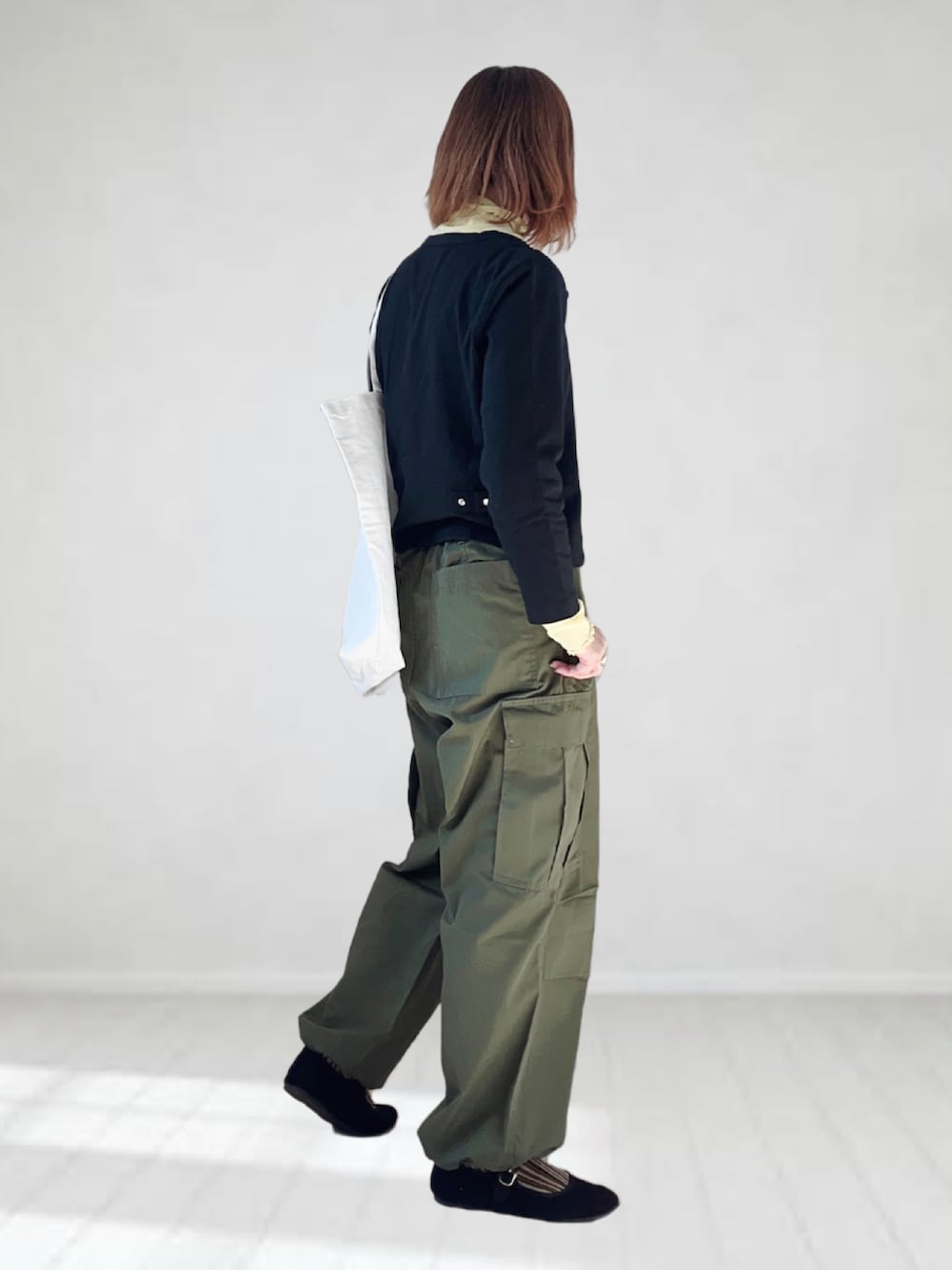 ブラック系のカーディガン/ボレロ、イエロー系のTシャツ/カットソー、グリーン系のカーゴパンツを着用したレディースの春コーディネートの3枚目の写真