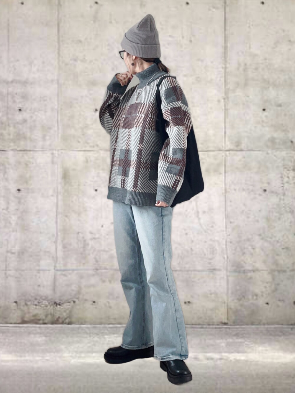 グレー系のニット/セーター、ブルー系のデニムパンツ、ブラック系のトートバッグを着用したレディースの冬コーディネートの2枚目の写真