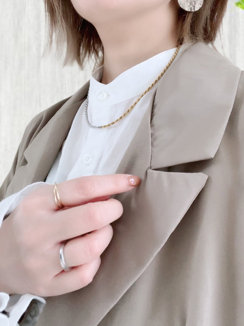 グレー系のテーラードジャケット、ホワイト系のシャツ/ブラウス、ブラック系のクラッチバッグを着用したレディースの冬コーディネートの2枚目の写真