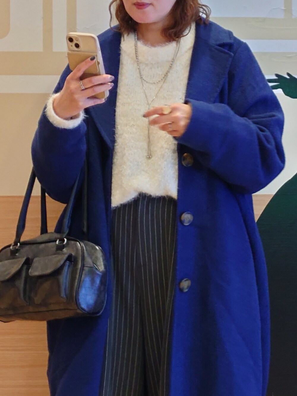 ホワイト系のニット/セーター、ブルー系のチェスターコート、グレー系のその他パンツを着用したレディースの冬コーディネートの5枚目の写真