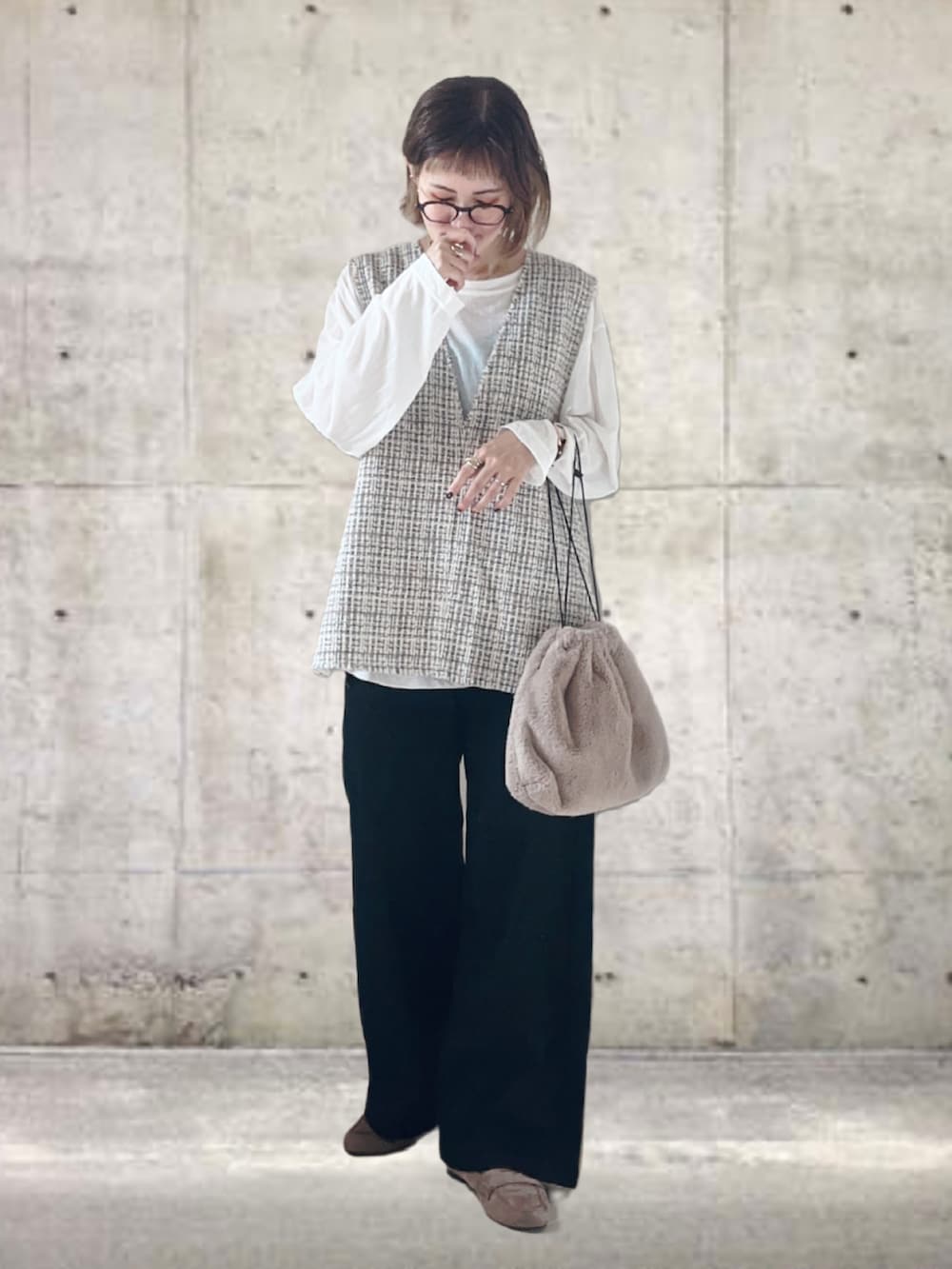 ホワイト系のベスト、ホワイト系のTシャツ/カットソー、ブラック系のデニムパンツを着用したレディースの秋コーディネートの3枚目の写真