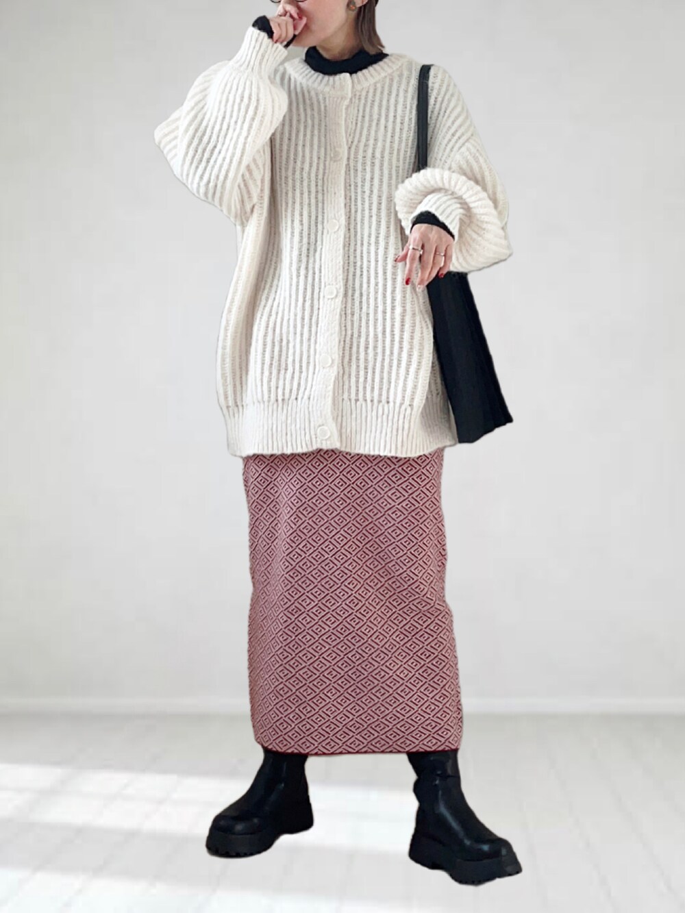 ホワイト系のカーディガン/ボレロ、ブラック系のTシャツ/カットソー、レッド系のスカートを着用したレディースの冬コーディネートの5枚目の写真