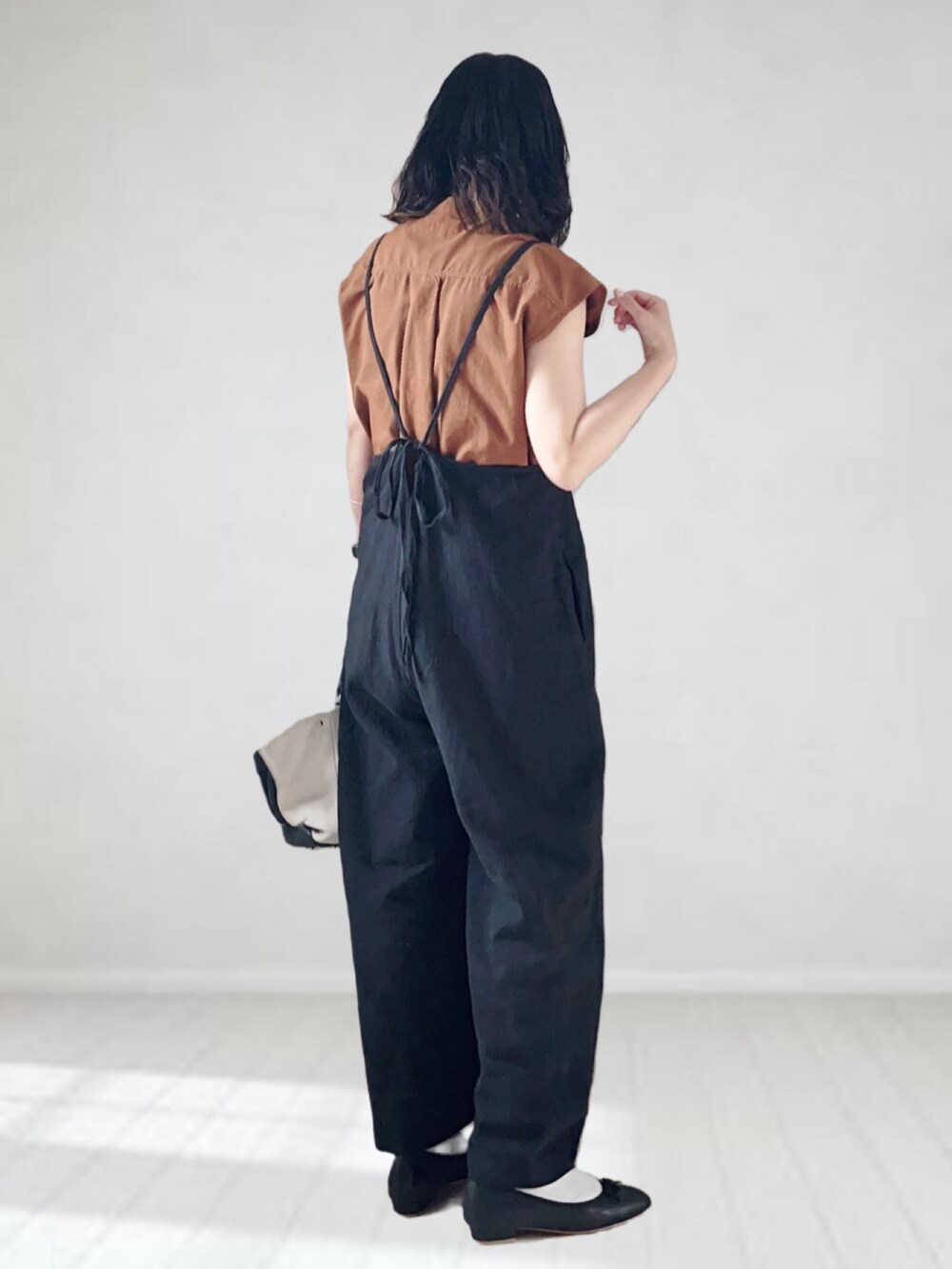 ブラック系のサロペット/オーバーオール、ブラウン系のシャツ/ブラウス、ホワイト系のバッグを着用したレディースの夏コーディネートの2枚目の写真