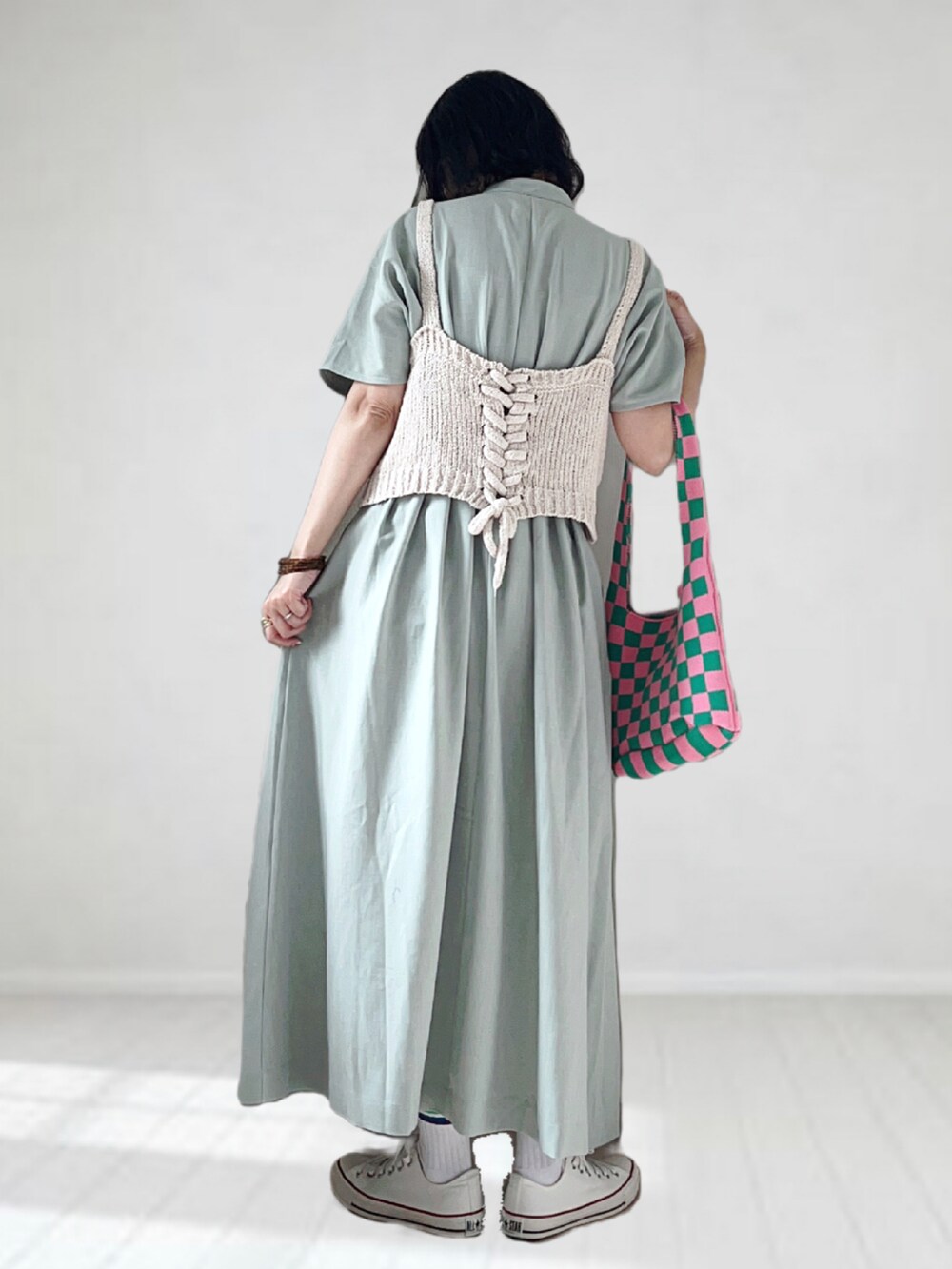 グリーン系のワンピース、ホワイト系のキャミソール、グリーン系のトートバッグを着用したレディースの夏コーディネートの2枚目の写真