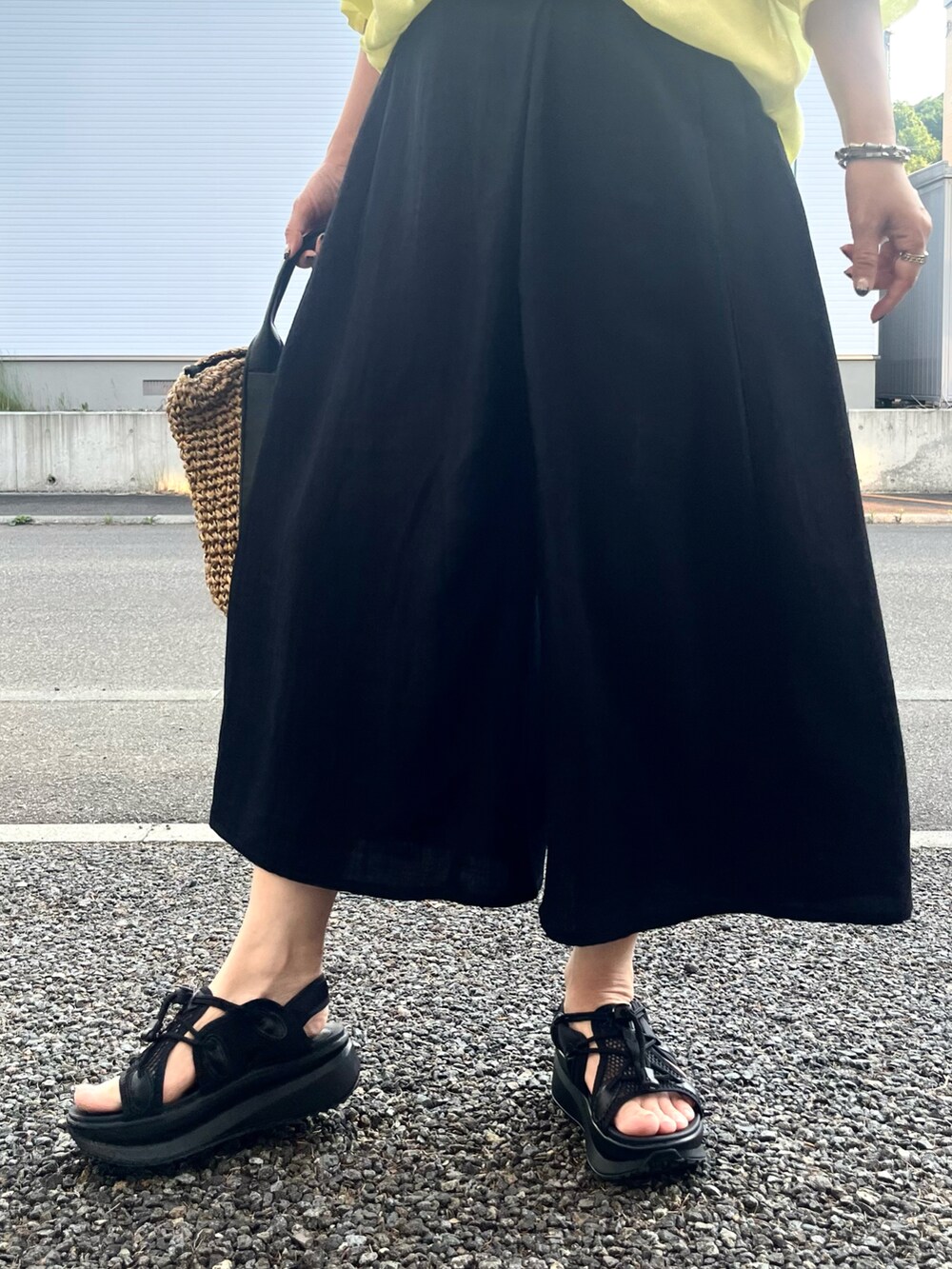 ブラック系のその他パンツ、ブラック系のショルダーバッグ、イエロー系のTシャツ/カットソーを着用したレディースの夏コーディネートの3枚目の写真