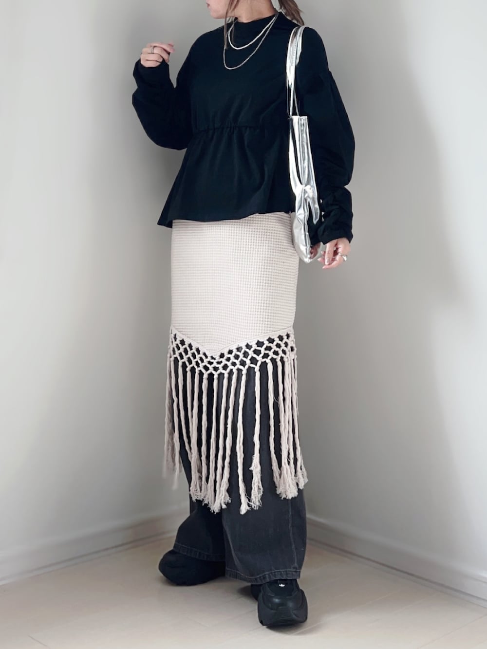 ブラック系のTシャツ/カットソー、ホワイト系のスカート、グレー系のデニムパンツを着用したレディースの春コーディネートの2枚目の写真