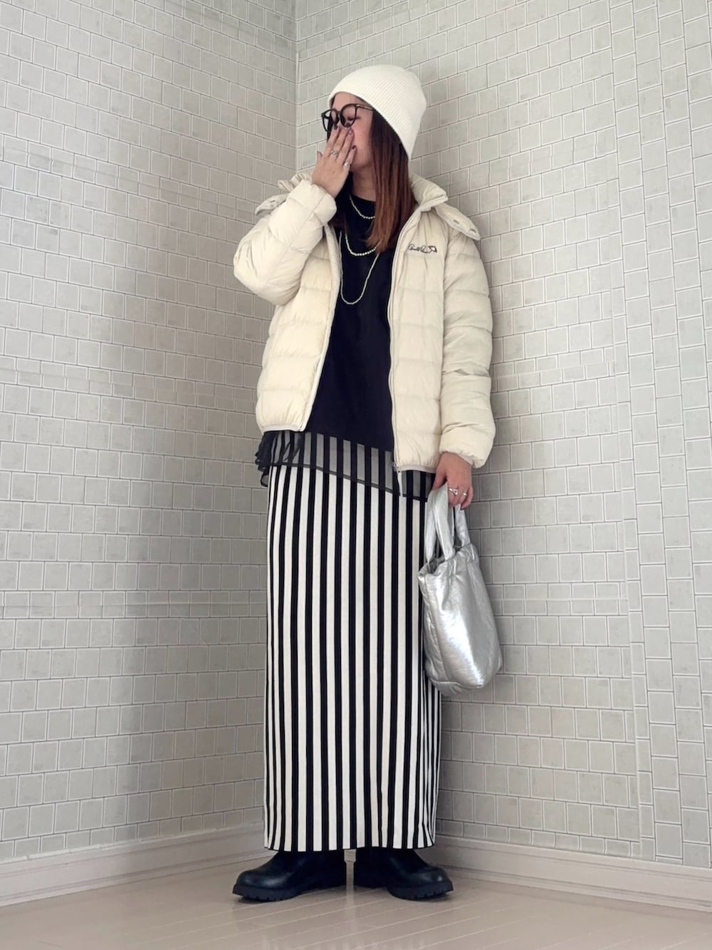 ホワイト系のダウンジャケット/コート、ブラック系のスウェット、ホワイト系のスカートを着用したレディースの秋コーディネートの2枚目の写真