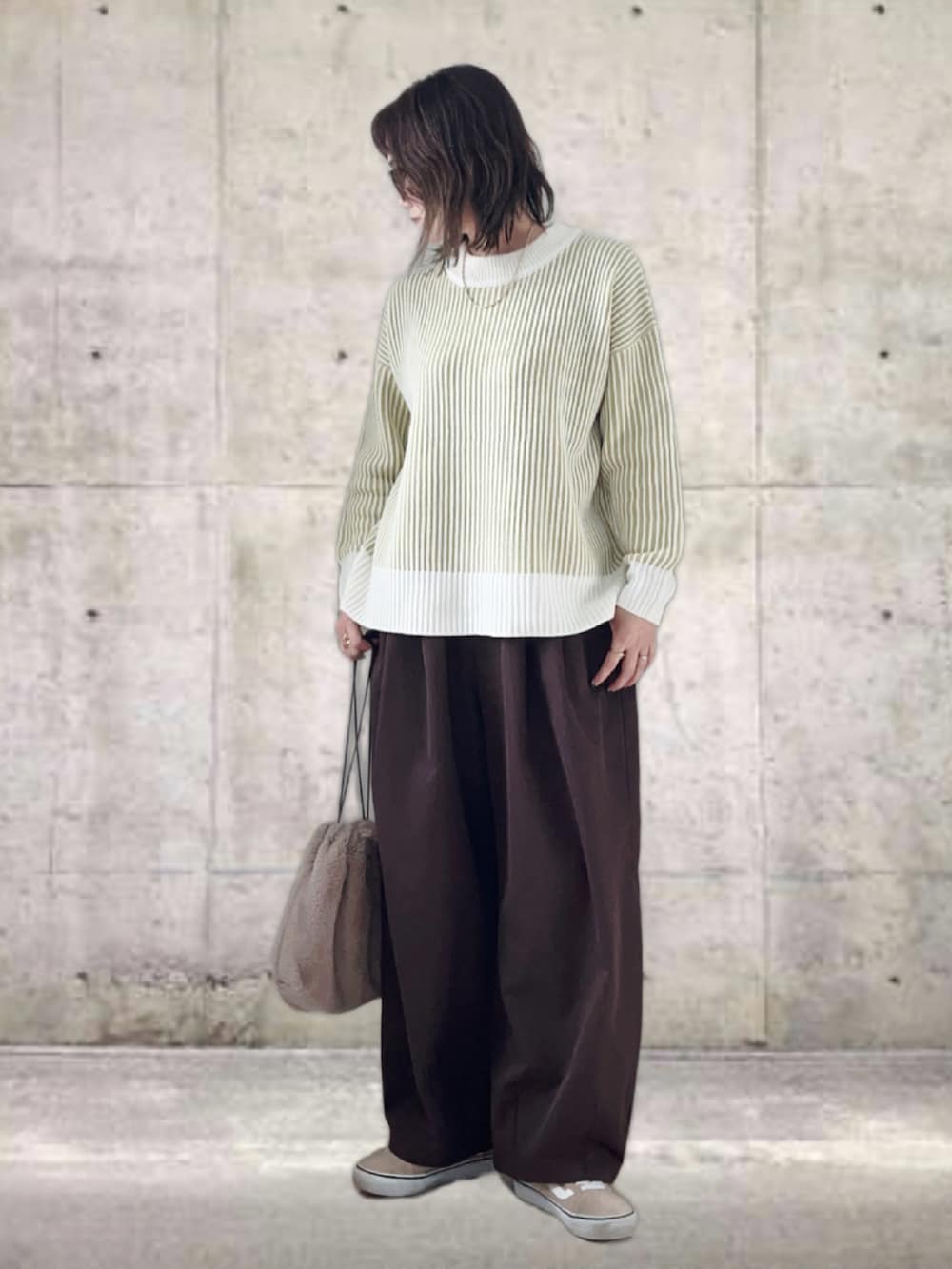 グリーン系のニット/セーター、ブラウン系のその他パンツ、ブラック系のショルダーバッグを着用したレディースの冬コーディネートの3枚目の写真