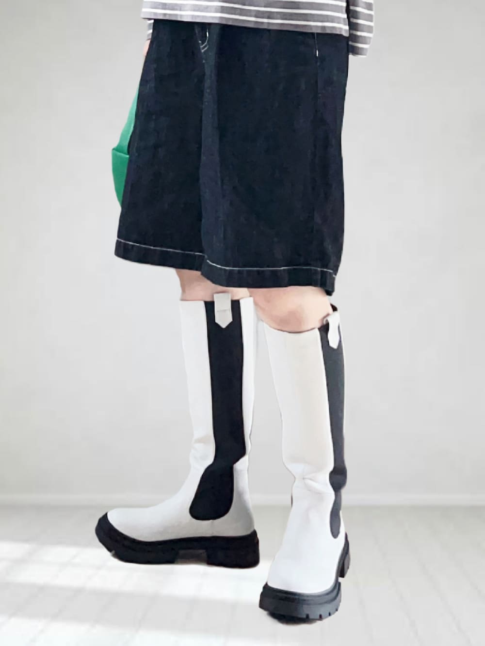 グレー系のTシャツ/カットソー、ホワイト系のブーツ、ブラック系のデニムパンツを着用したレディースの秋コーディネートの4枚目の写真