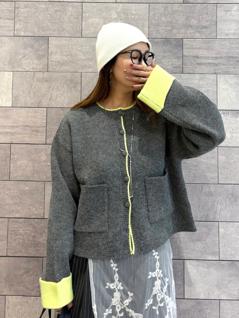 グレー系のカーディガン/ボレロ、グレー系のその他パンツ、ブラック系のボストンバッグを着用したレディースの秋コーディネートの4枚目の写真