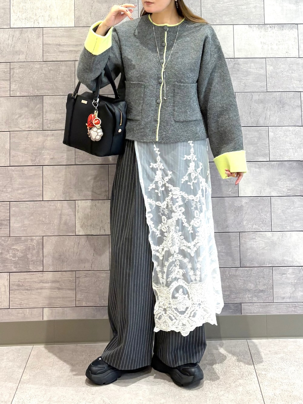 グレー系のカーディガン/ボレロ、グレー系のその他パンツ、ブラック系のボストンバッグを着用したレディースの秋コーディネートの3枚目の写真