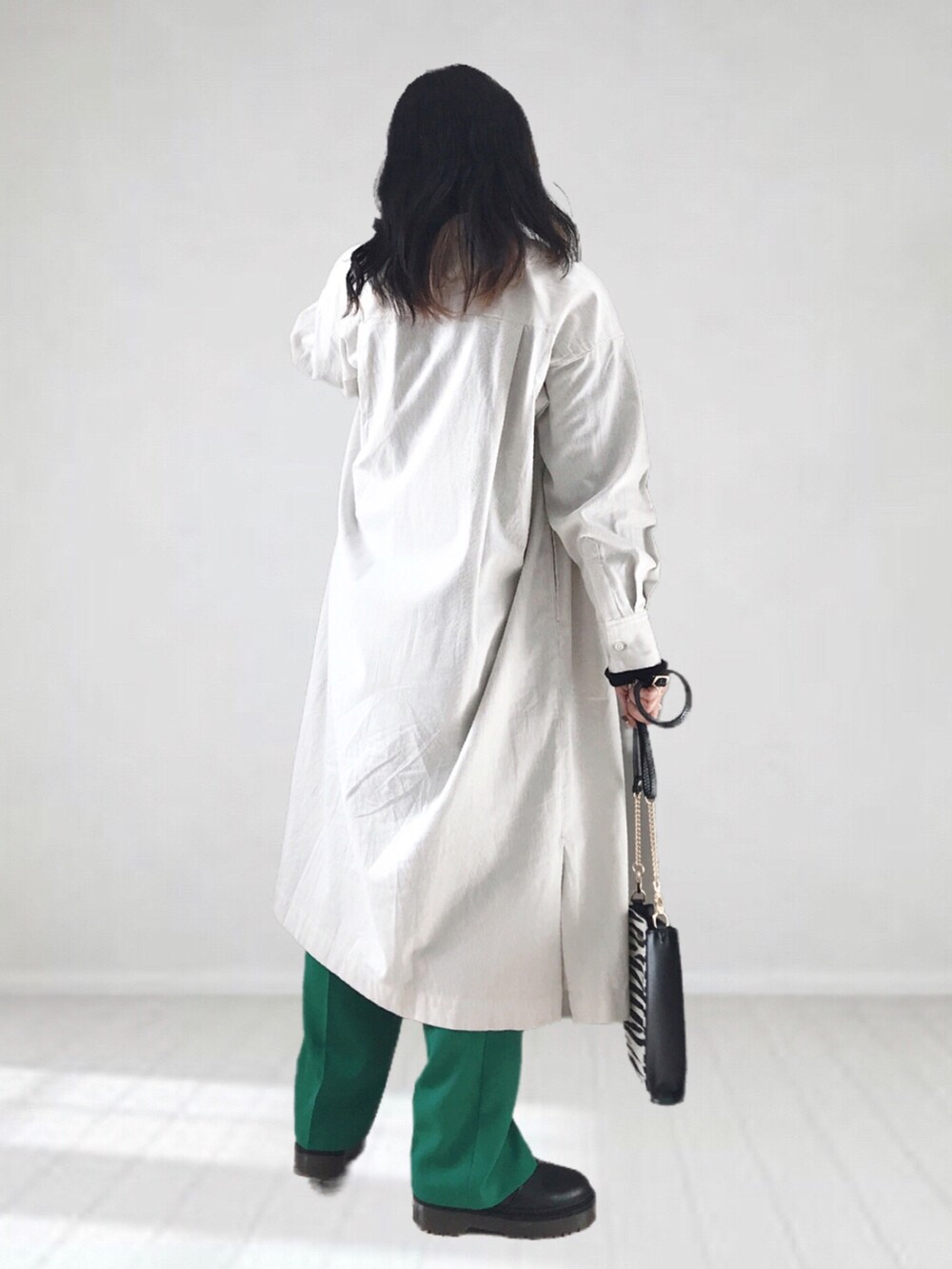 ベージュ系のワンピース、ブラック系のTシャツ/カットソー、ホワイト系のショルダーバッグを着用したレディースの冬コーディネートの2枚目の写真