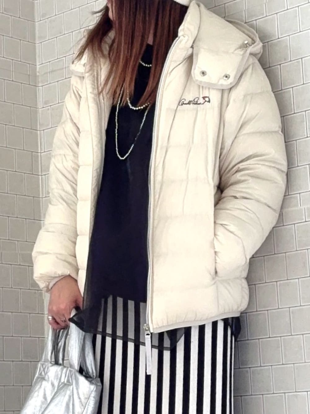 ホワイト系のダウンジャケット/コート、ブラック系のスウェット、ホワイト系のスカートを着用したレディースの秋コーディネートの5枚目の写真