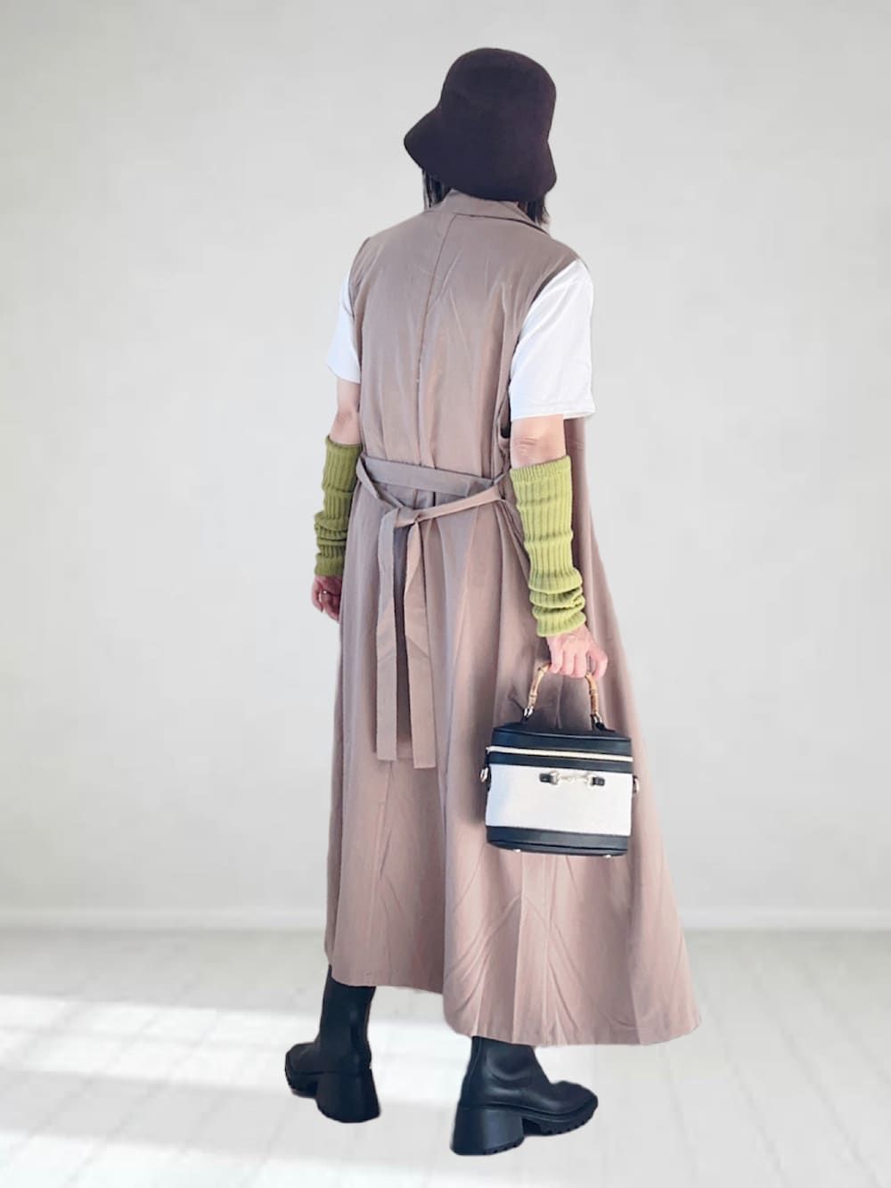 ベージュ系のベスト、ホワイト系のTシャツ/カットソー、ブラック系のデニムパンツを着用したレディースの秋コーディネートの3枚目の写真