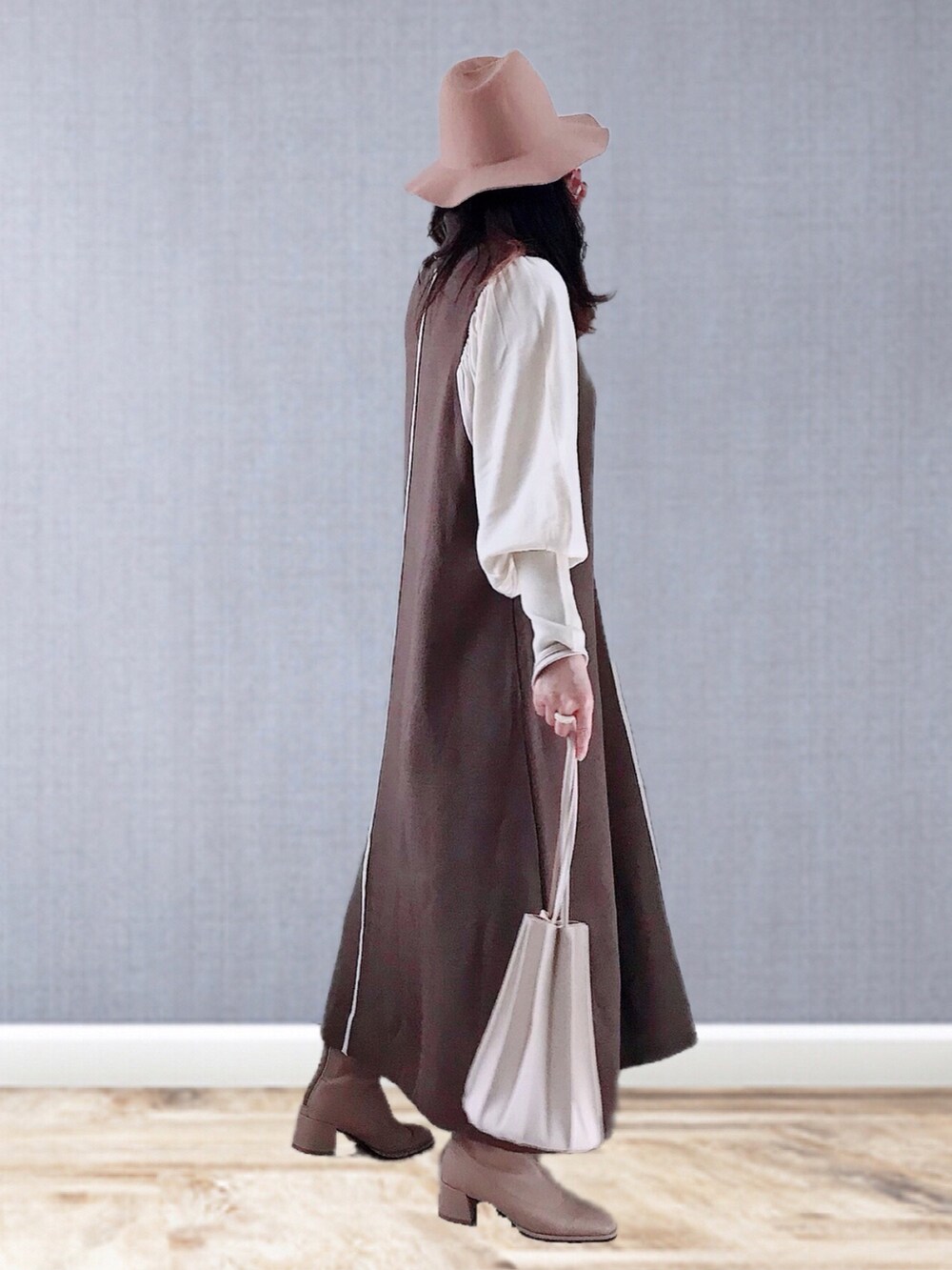 ブラウン系のワンピース、ベージュ系のショルダーバッグ、ベージュ系のブーツを着用したレディースの冬コーディネートの4枚目の写真