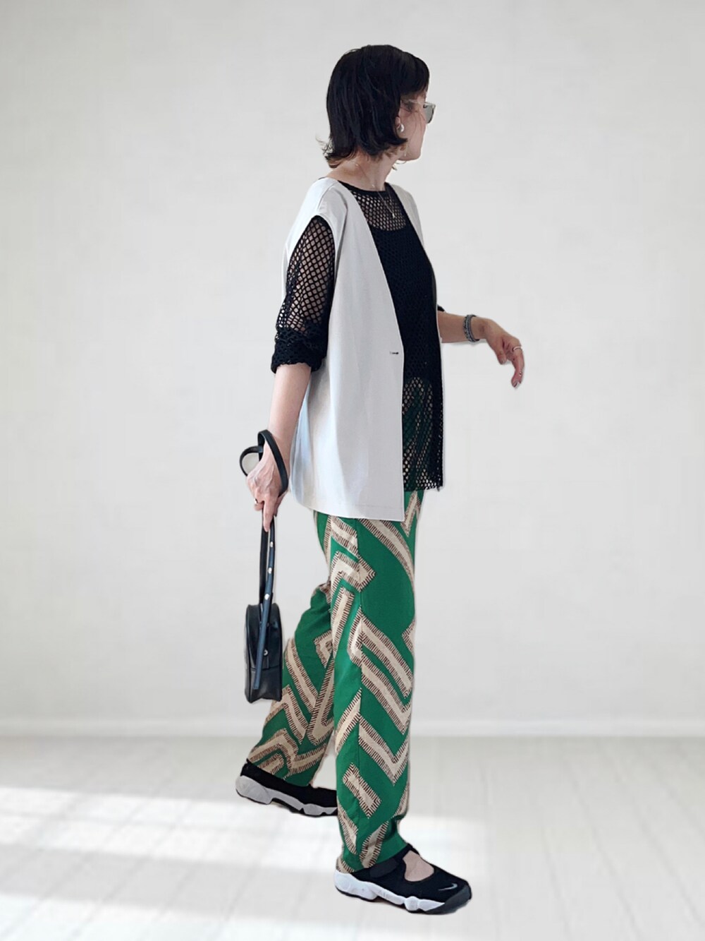 グリーン系のその他パンツ、ベージュ系のベスト、ブラック系のTシャツ/カットソーを着用したレディースの夏コーディネートの2枚目の写真