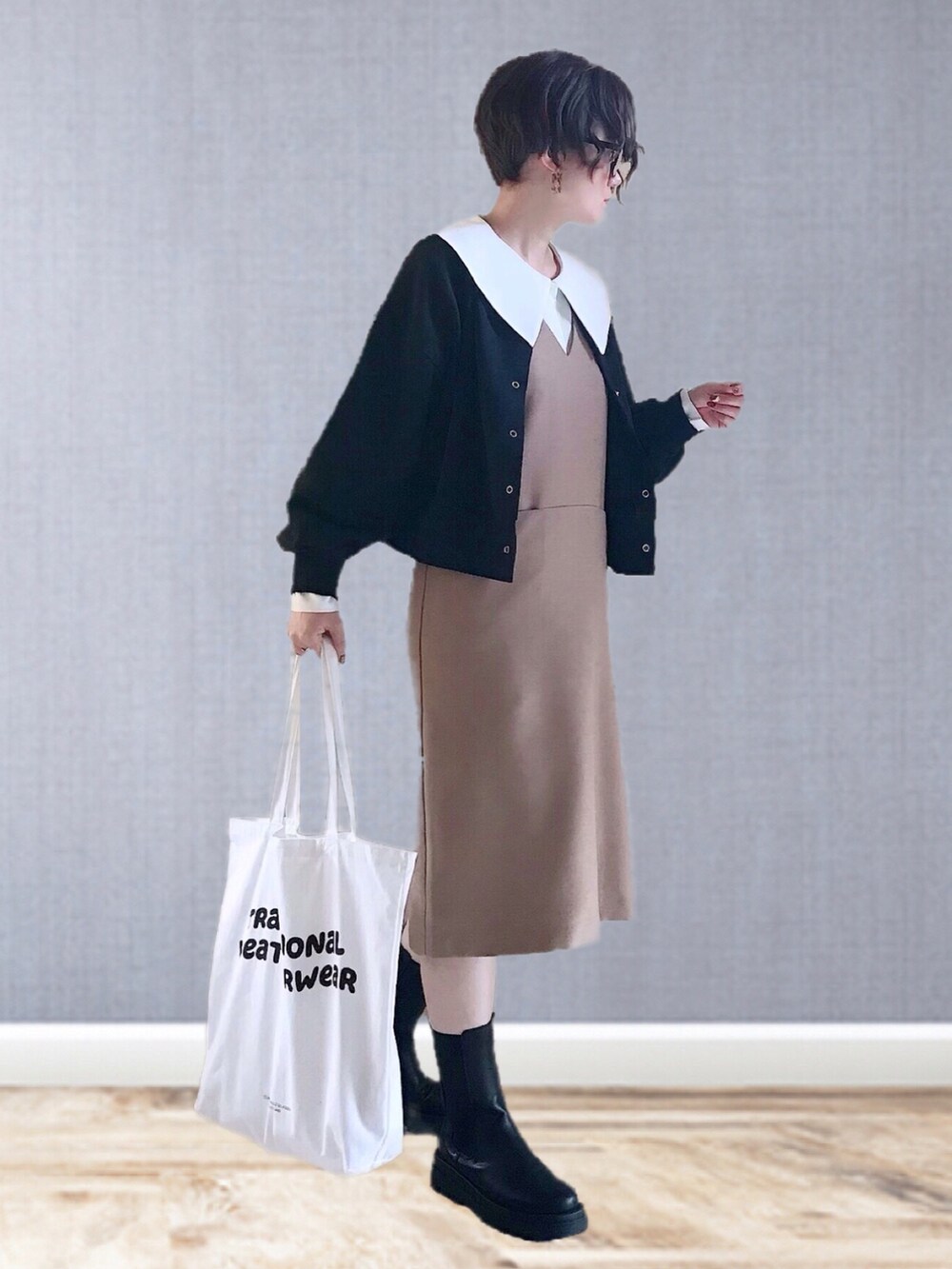 ベージュ系のワンピース、グリーン系のシャツ/ブラウス、ブラック系のスウェットを着用したレディースの冬コーディネートの2枚目の写真