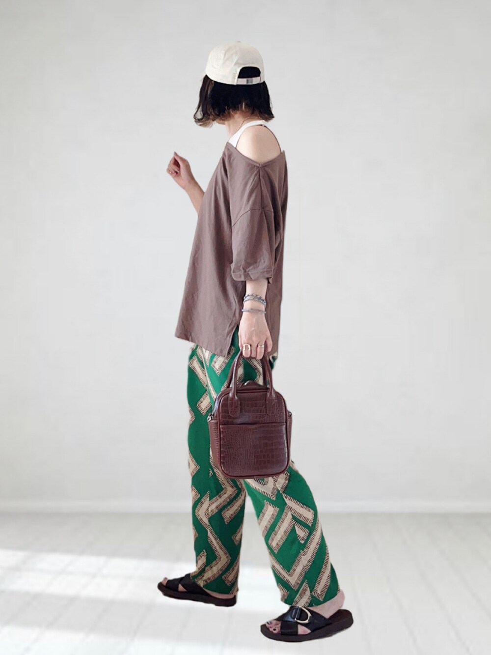 グリーン系のその他パンツ、ブラウン系のTシャツ/カットソー、ブラウン系のハンドバッグを着用したレディースの夏コーディネートの2枚目の写真