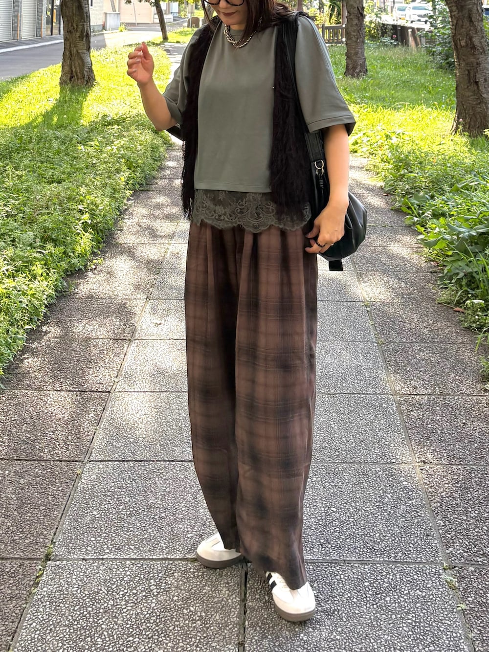 ブラウン系のその他パンツ、ブラック系のショルダーバッグ、ホワイト系のスニーカーを着用したレディースの秋コーディネートの3枚目の写真