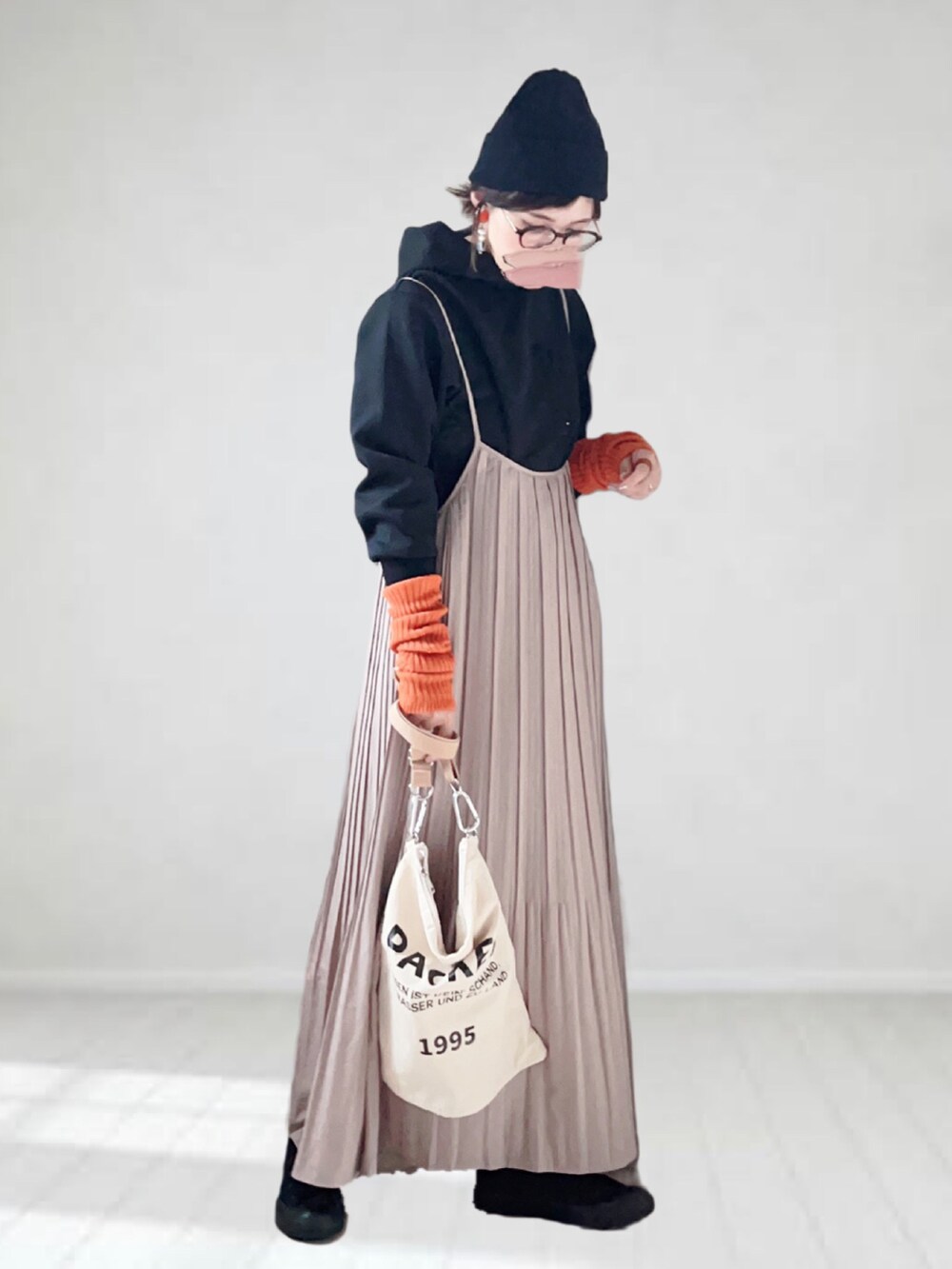 ブラック系のパーカー、ブラウン系のワンピース、ベージュ系のトートバッグを着用したレディースの秋コーディネートの3枚目の写真