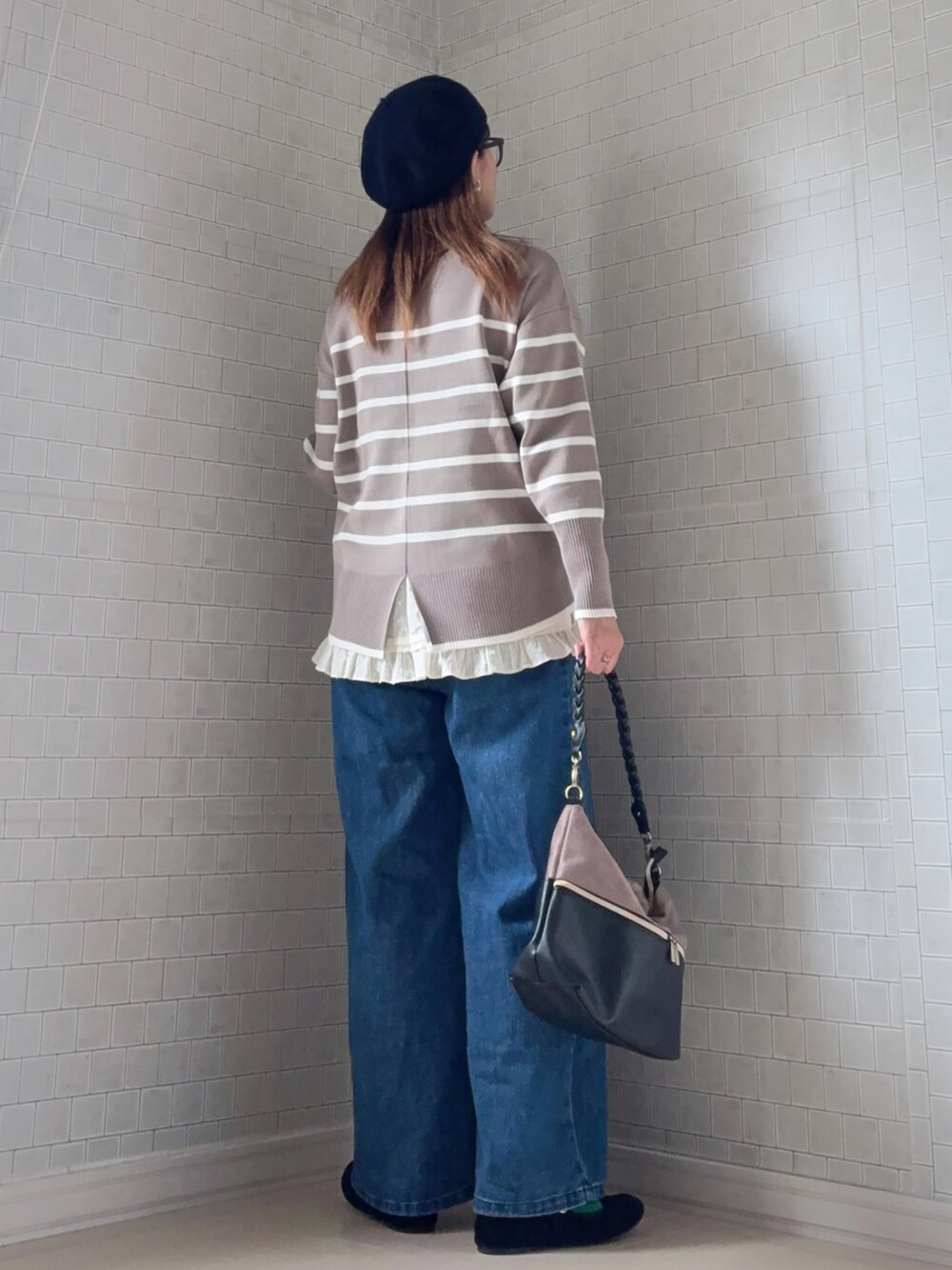 ベージュ系のニット/セーター、ブラック系のショルダーバッグ、ブルー系のデニムパンツを着用したレディースの冬コーディネートの2枚目の写真