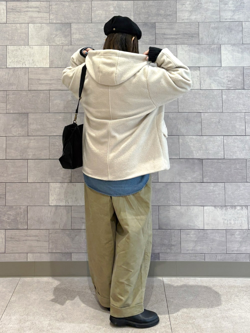 ブラック系のショルダーバッグ、ホワイト系のブルゾン、ブラック系のニット/セーターを着用したレディースの冬コーディネートの3枚目の写真