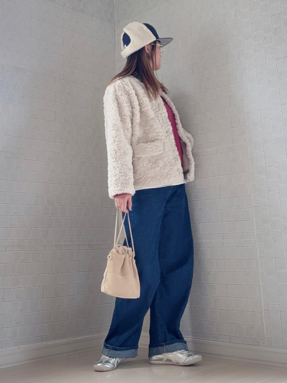 パープル系のスウェット、ベージュ系のノーカラーコート、ブルー系のデニムパンツを着用したレディースの秋コーディネートの4枚目の写真