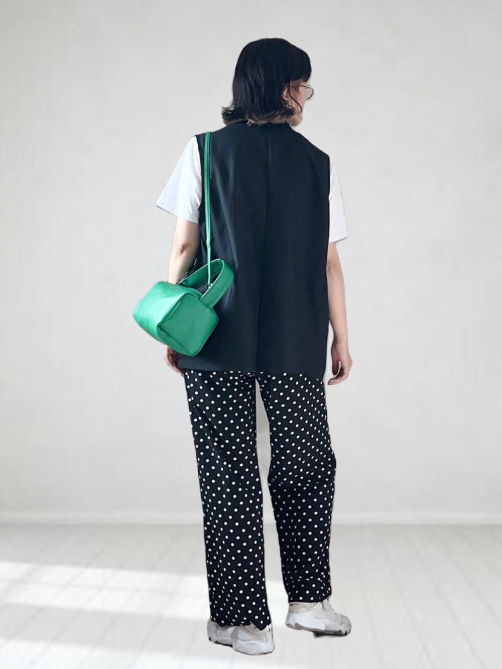 ブラック系のその他パンツ、ブラック系のベスト、ホワイト系のTシャツ/カットソーを着用したレディースの夏コーディネートの3枚目の写真