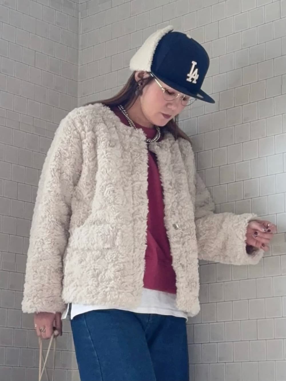 パープル系のスウェット、ベージュ系のノーカラーコート、ブルー系のデニムパンツを着用したレディースの秋コーディネートの5枚目の写真