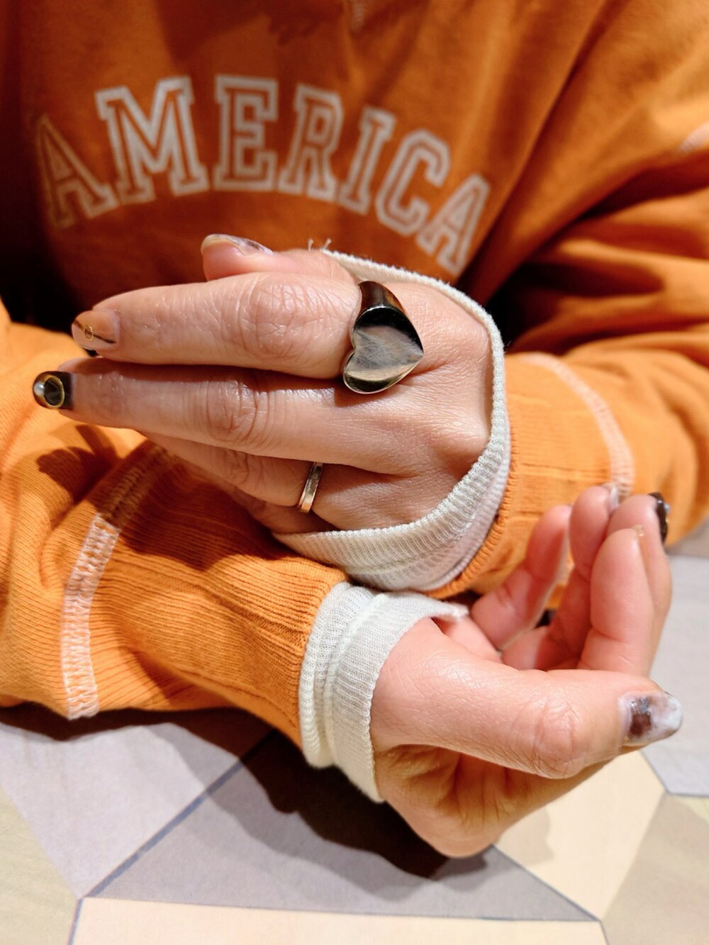 ブラック系のブルゾン、オレンジ系のスウェット、ホワイト系のTシャツ/カットソーを着用したレディースの冬コーディネートの5枚目の写真