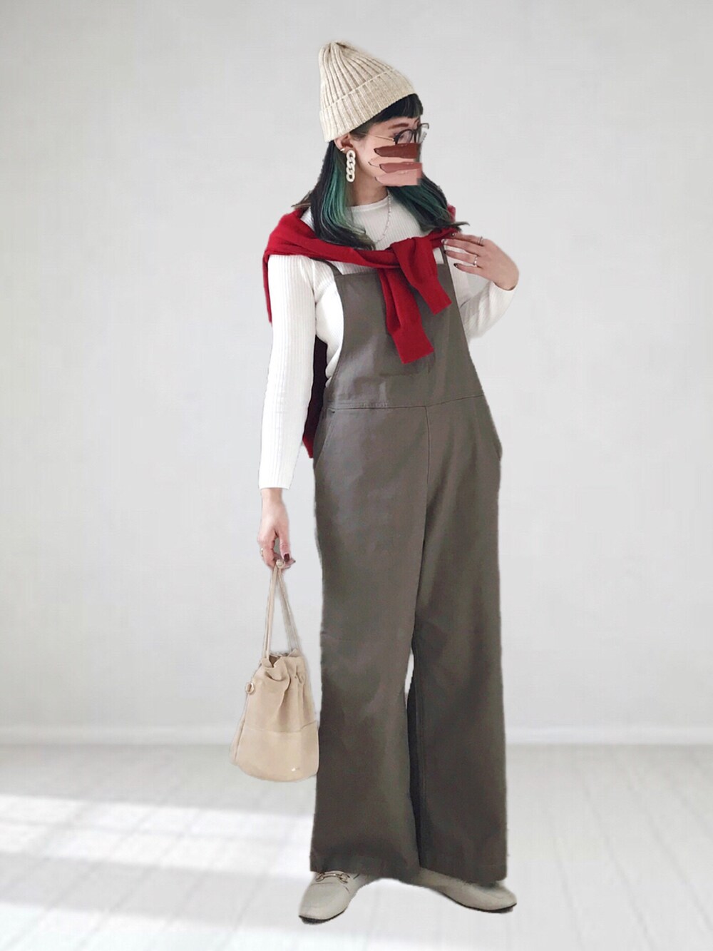 ホワイト系のニット/セーター、レッド系のカーディガン/ボレロ、グリーン系のサロペット/オーバーオールを着用したレディースの冬コーディネートの2枚目の写真